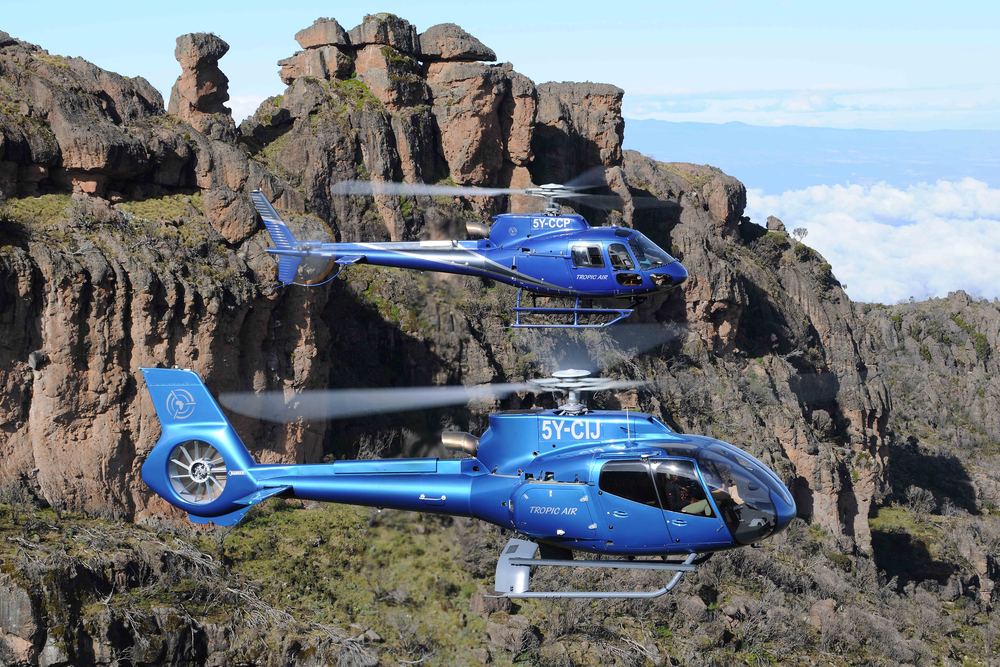 Tropic Air helicopter in flight over Kenya's landscape